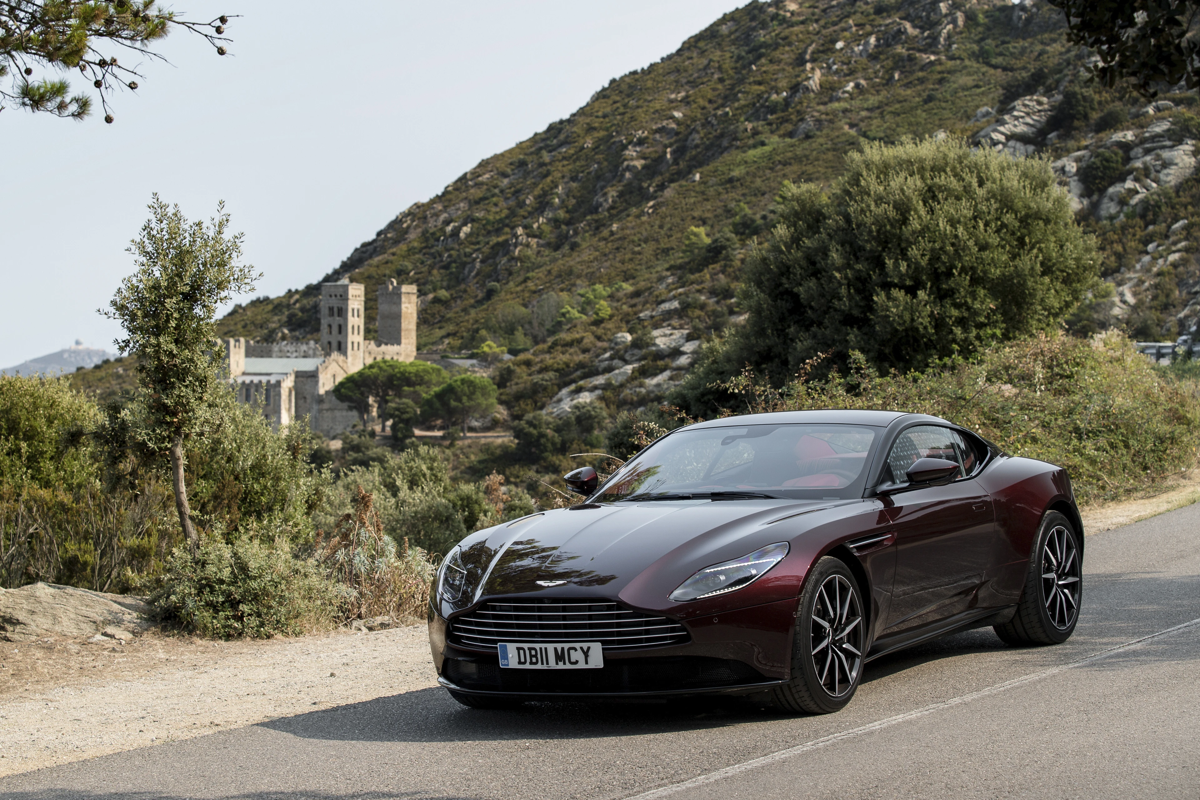 DB11 V8 in Divine Red on a Mountain Road